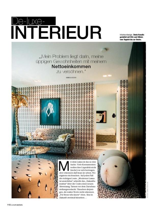 Ein Wohnzimmer mit gemusterten Tapeten, einem Sofa und dekorativen Elementen.