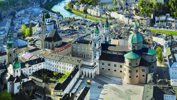 Luftaufnahme der Stadt Salzburg mit der Salzburger Kathedrale im Vordergrund.