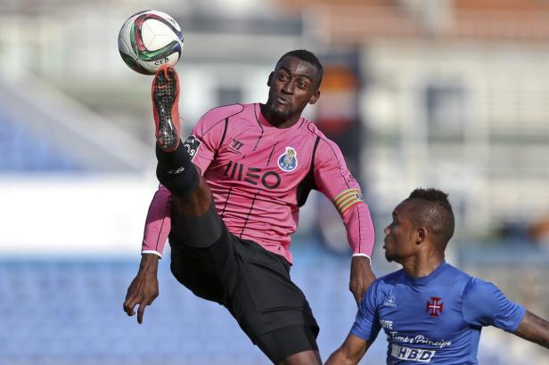 Ein Fußballspieler in einem pinkfarbenen Trikot balanciert einen Ball auf seinem Fuß.
