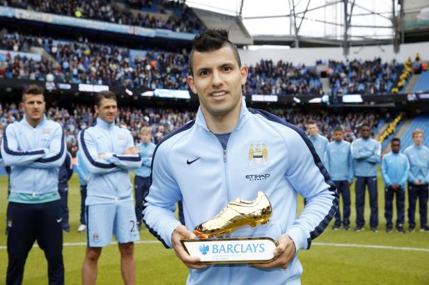 Sergio Agüero hält eine goldene Trophäe in Form eines Fußballschuhs in die Kamera.