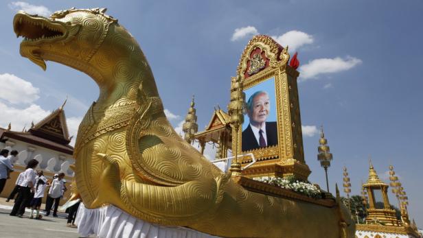 Ein goldener Festwagen in Form eines Fabelwesens mit einem Porträt eines Mannes darauf.