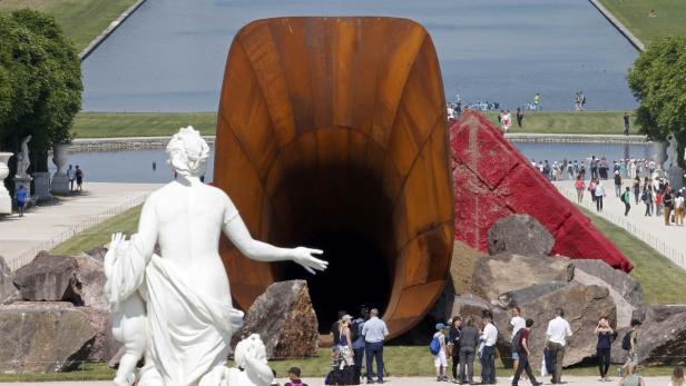 People walk near Indian-born British artist Anish