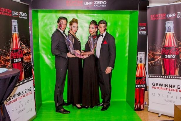 (beide bilder c: kesch branding) Vier Personen posieren mit futuristischem Make-up vor einem grünen Hintergrund und Coca-Cola Zero Werbung.