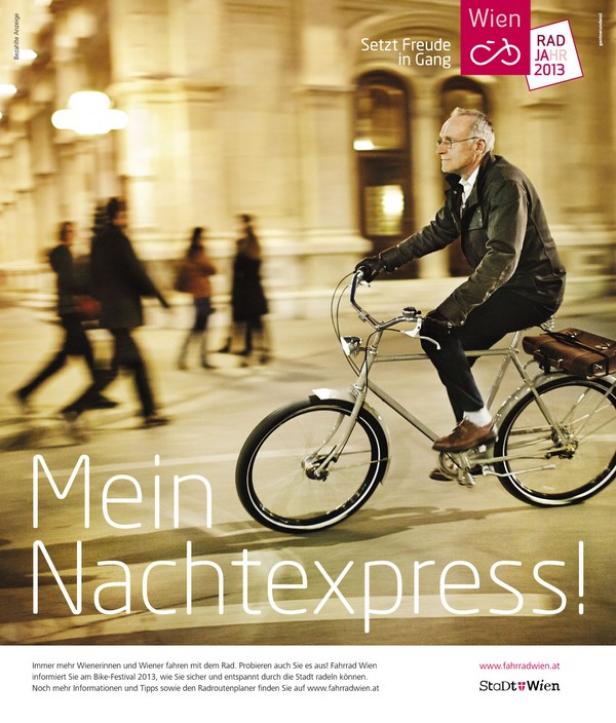 Ein älterer Mann fährt nachts mit dem Fahrrad durch Wien.