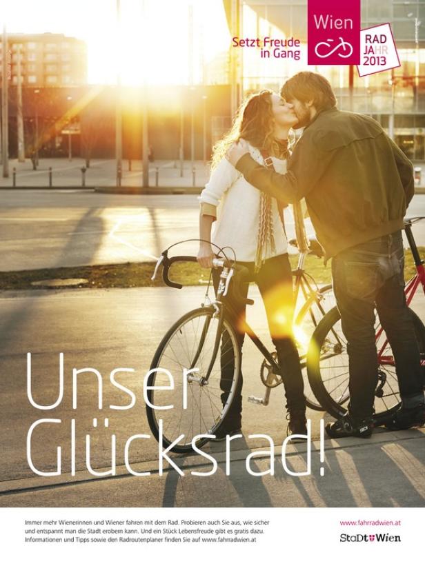 Ein Paar küsst sich neben ihren Fahrrädern in Wien, im Hintergrund die untergehende Sonne.