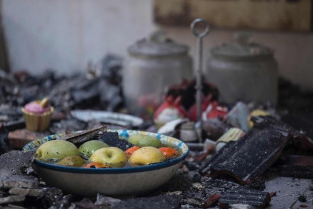 Eine Schüssel mit Früchten steht inmitten von Trümmern.