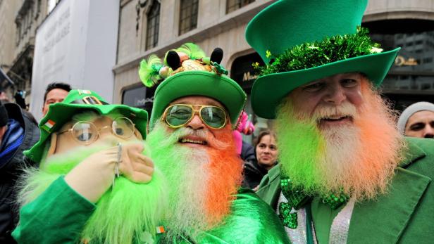 Drei Männer mit grün gefärbten Bärten und Hüten feiern den St. Patrick's Day.