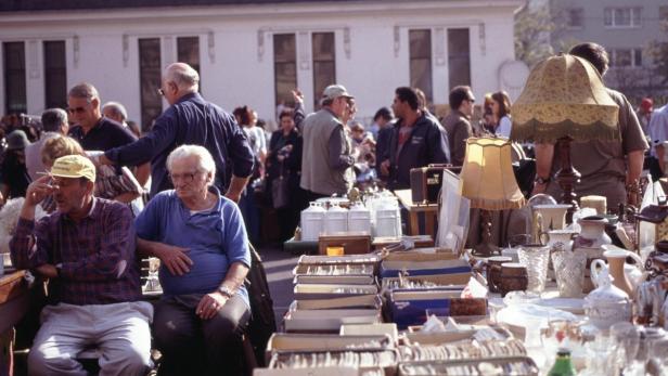 Ein belebter Flohmarkt mit vielen Menschen und Verkaufsständen.