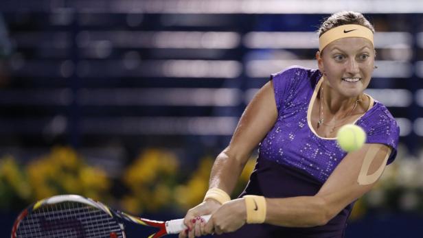 Eine Tennisspielerin schlägt einen Ball mit ihrem Schläger.