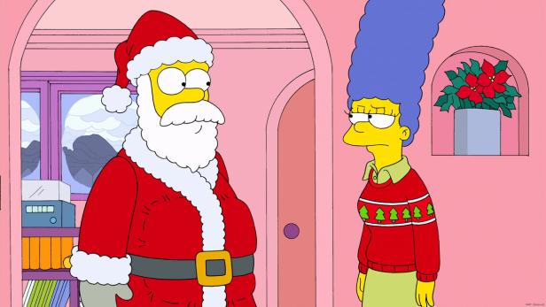 Homer Simpson als Weihnachtsmann und Marge Simpson in Weihnachtskleidung stehen in einem Raum.