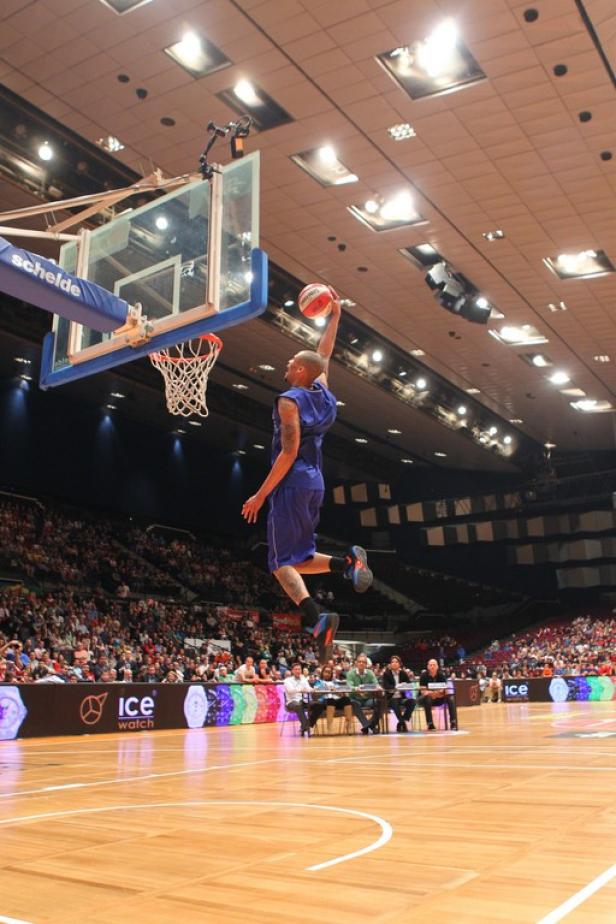 Ein Basketballspieler springt, um den Ball in einem Spiel in den Korb zu werfen.
