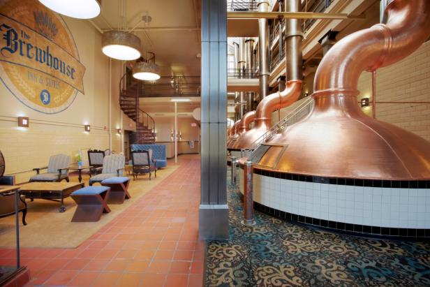 Innenansicht des Brewhouse Inn & Suites mit Kupferbraukesseln und Sitzecke.