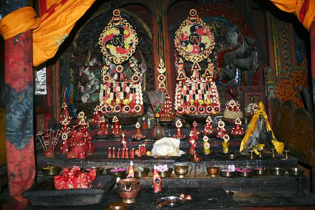 Ein reich verzierter buddhistischer Altar mit Opfergaben und religiösen Symbolen.