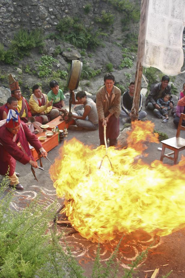 Buddhistische Mönche führen eine Feuerzeremonie im Freien durch.