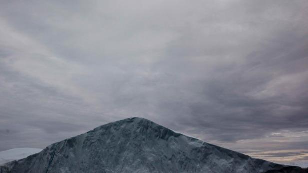 Ein schneebedeckter Berg unter einem bewölkten Himmel.