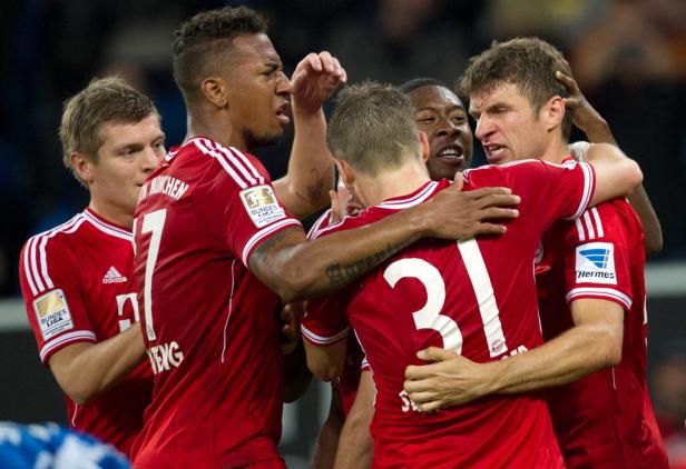 Spieler des FC Bayern München umarmen sich auf dem Spielfeld.