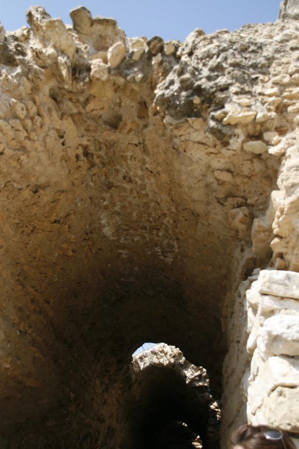 Blick durch einen alten, steinernen Tunnel zum hellen Tageslicht.