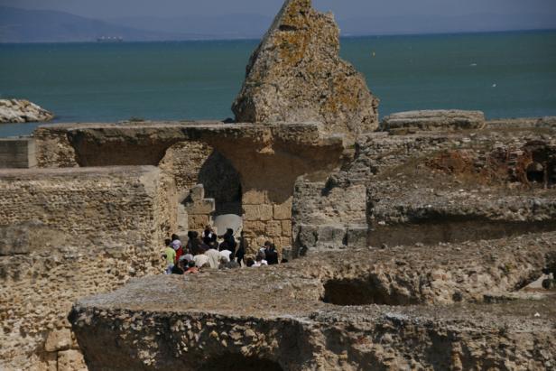 Eine Gruppe von Menschen besichtigt die Ruinen von Karthago in Tunesien.