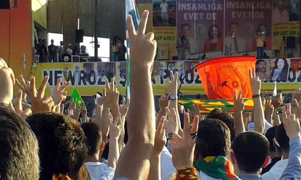 Eine Menschenmenge zeigt das Victory-Zeichen bei einer Newroz-Feier.