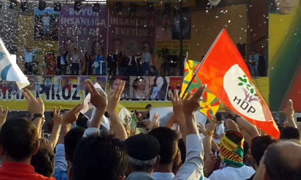 Menschenmenge jubelt auf einer HDP-Kundgebung mit Konfetti und Fahnen.