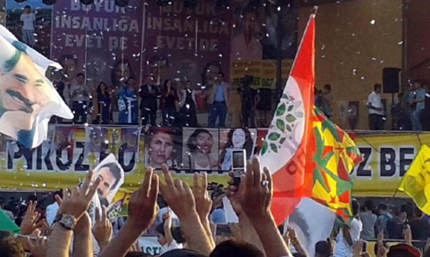 Eine Menschenmenge demonstriert mit Fahnen und Transparenten bei einer politischen Kundgebung.