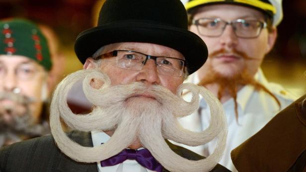 Ein Mann mit Hut und einer kunstvoll gezwirbelten Bartfrisur.