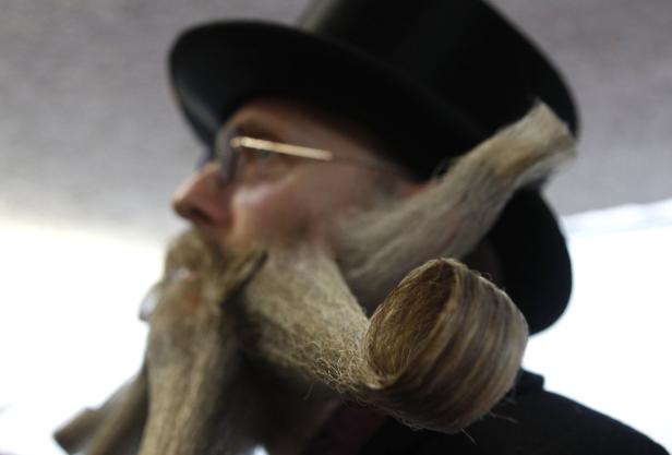 Ein Mann mit Hut und kunstvoll gezwirbeltem Bart.