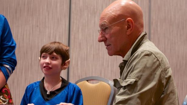 Patrick Stewart mit einem Kind, das als Spock verkleidet ist.
