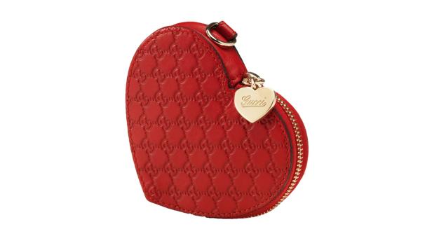Eine herzförmige, rote Gucci-Tasche mit goldenem Reißverschluss und Herzanhänger.