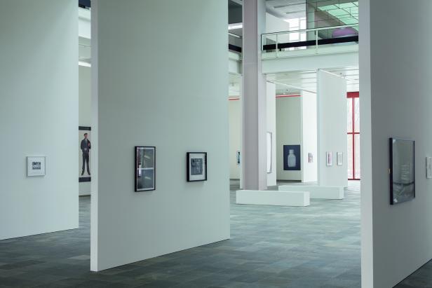 Eine Ausstellungshalle mit mehreren Kunstwerken an den Wänden.
