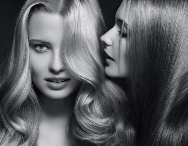 Zwei Frauen mit langen, gewellten Haaren in verschiedenen Blondtönen.