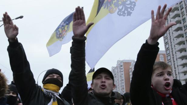 Menschen demonstrieren mit den Flaggen des Russischen Kaiserreichs.