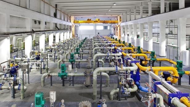 Eine große Industriehalle mit zahlreichen Rohren und Anlagen.