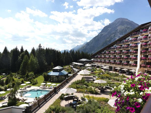 Ein Hotelresort mit Pool, Garten und Blick auf die Berge.