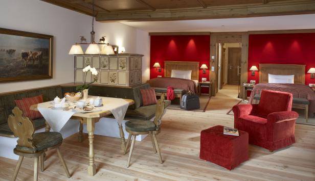 Ein traditionell eingerichtetes Hotelzimmer mit Essbereich und Betten in Österreich.