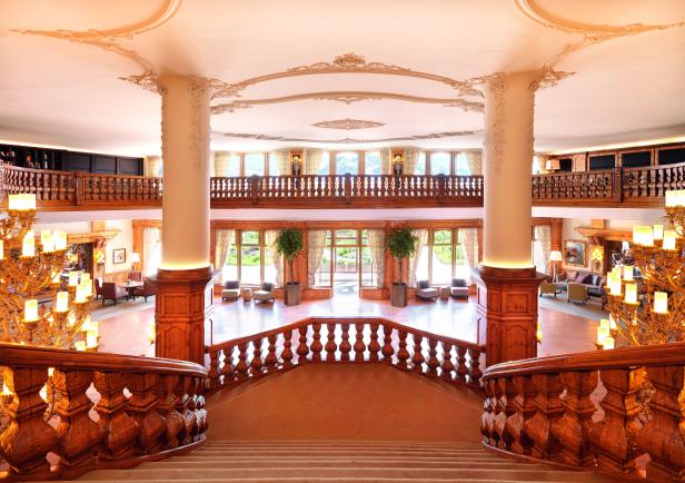 Blick von einer Treppe in die Lobby eines luxuriösen Hotels.