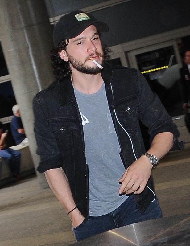 Kit Harington mit Zigarette im Mund und schwarzer Jacke.