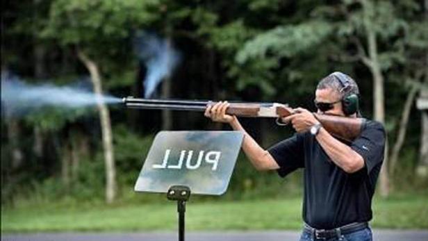 Barack Obama schießt mit einer Flinte auf einem Schießstand.