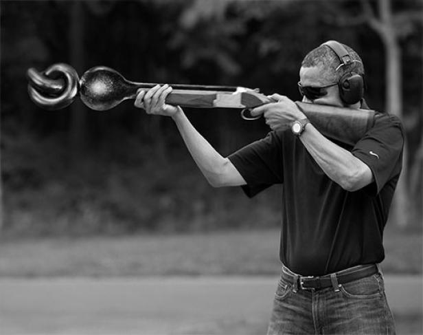 Ein Mann zielt mit einem Gewehr, dessen Lauf in einem Knoten endet.