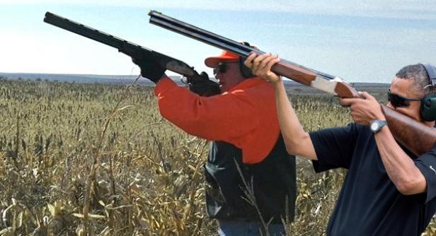 Zwei Männer zielen mit Schrotflinten auf einem Feld.