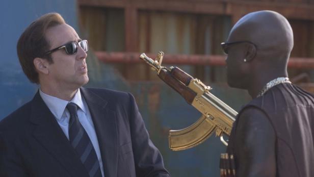 Nicolas Cage steht einem Mann mit einer goldenen AK-47 gegenüber.
