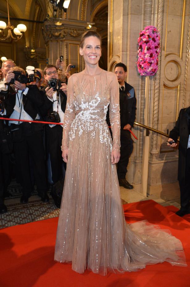 Hilary Swank in einem langen, verzierten Kleid auf einem roten Teppich.