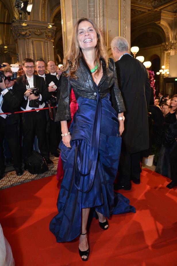 Eine Frau in einem auffälligen blauen Kleid auf einem roten Teppich.