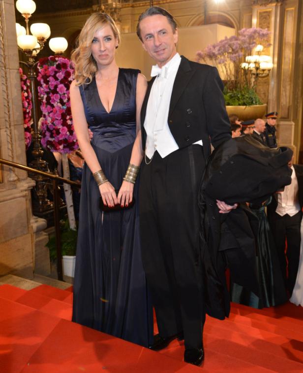 Ein Paar in Abendgarderobe posiert auf einem roten Teppich.