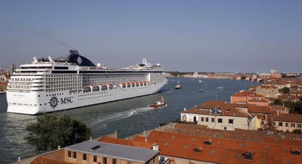 Ein großes MSC-Kreuzfahrtschiff fährt durch einen Kanal in Venedig.