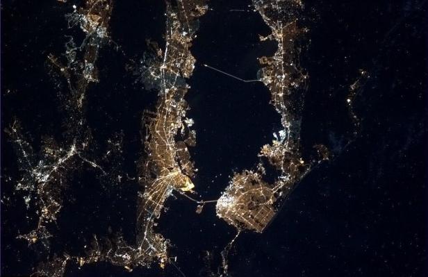 Nachtsicht auf eine Stadt, möglicherweise New York, aus dem Weltraum.
