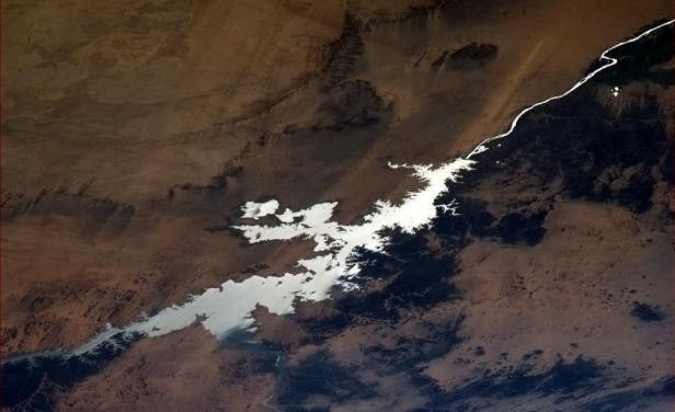 Eine Luftaufnahme eines Sees inmitten einer trockenen, wüstenartigen Landschaft.