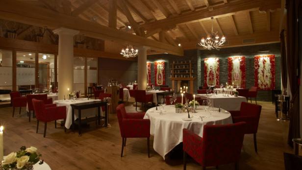 Ein elegantes Restaurant mit gedeckten Tischen und rotem Mobiliar.