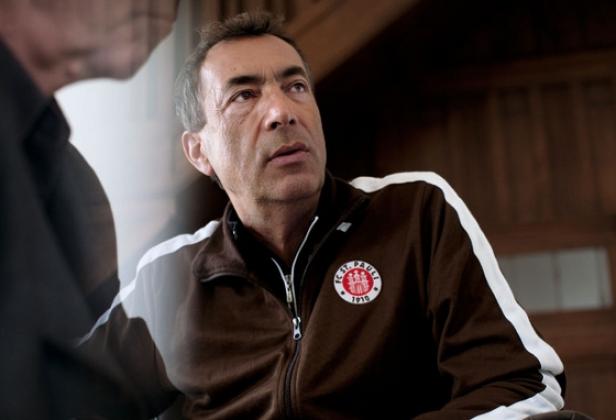 Ein Mann mit brauner FC St. Pauli Jacke schaut aufmerksam zur Seite.