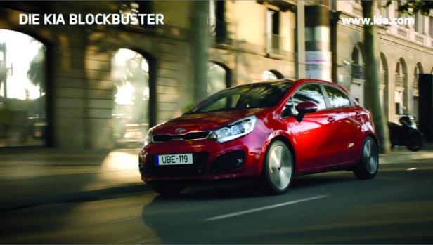 Ein roter Kia Rio fährt auf einer Straße in der Stadt.